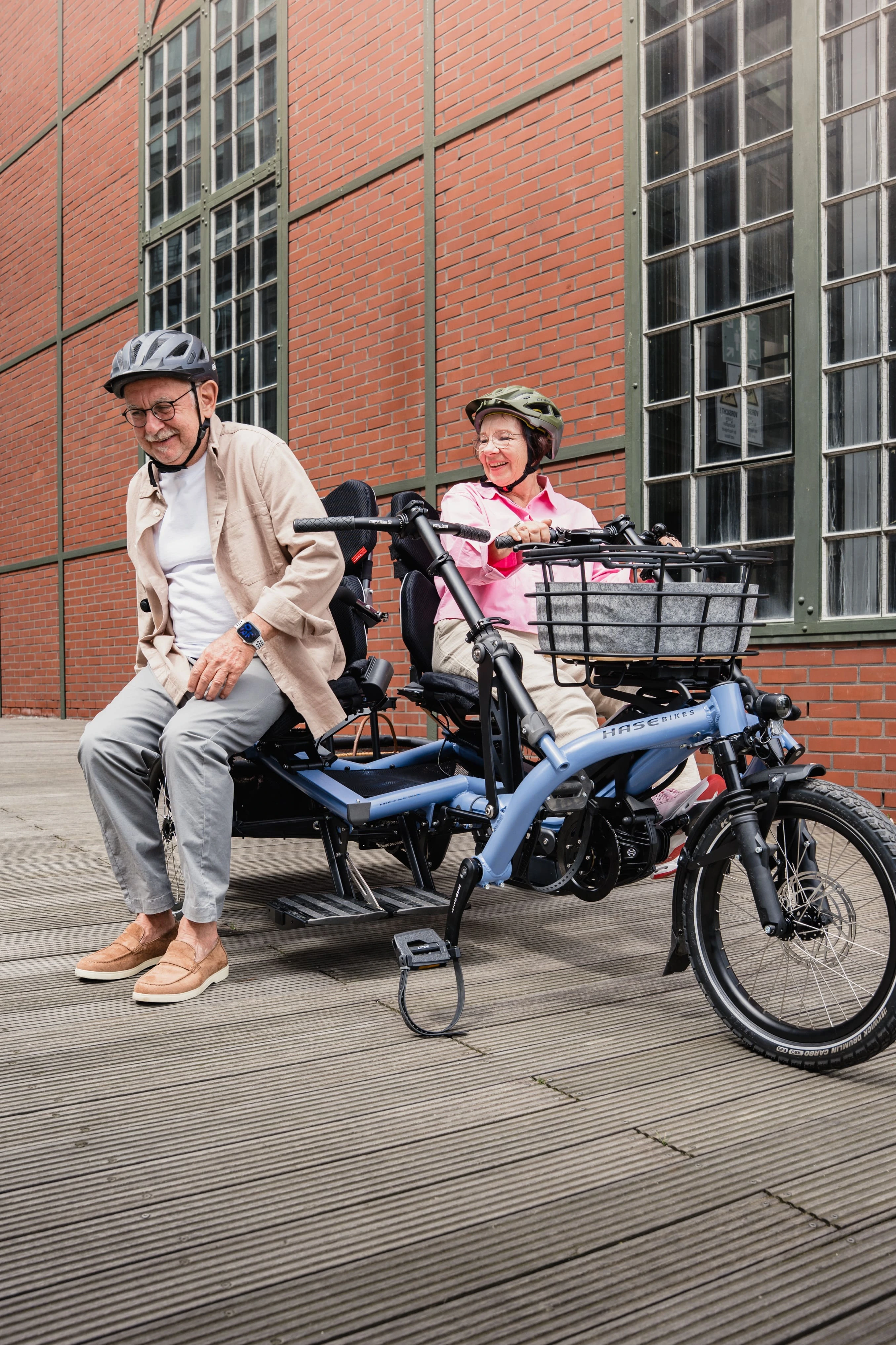 Mann steht von dem Kettwiesel TWO Paralleltandem auf und die Frau bleibt auf dem Rad sitzen