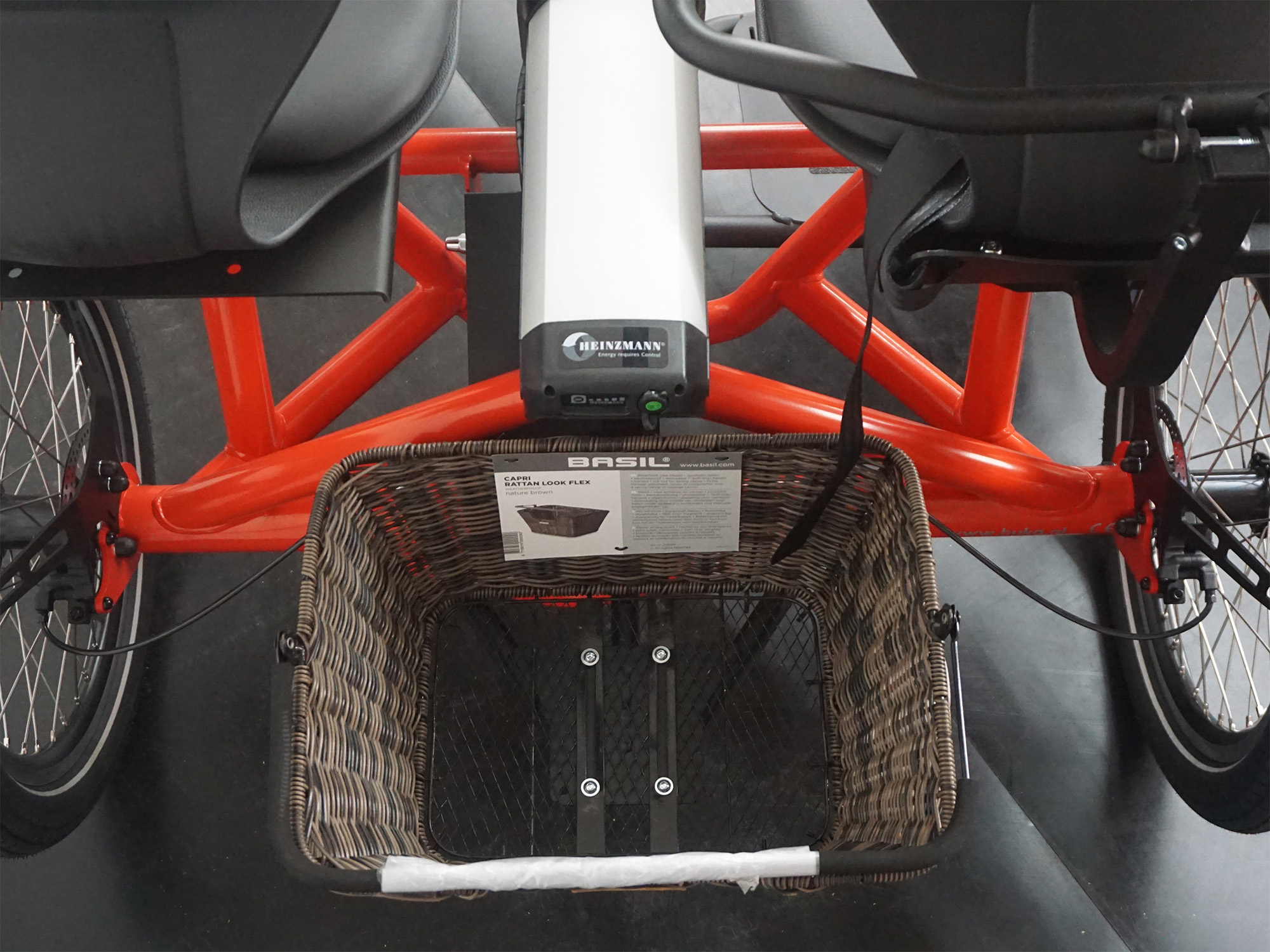 Rückansicht eines Tandem-E-Bikes mit Go SwissDrive-Akku und geflochtenem BASIL-Fahrradkorb.