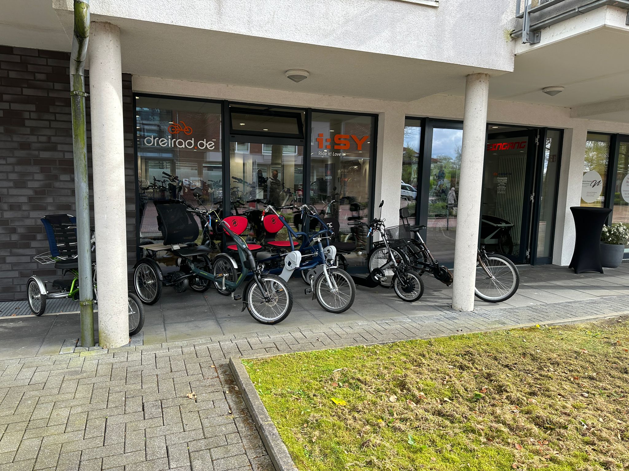  Dreiräder und Spezialräder vor dem Laden von dreirad.de und i:SY – Außenansicht mit Schaufenstern.