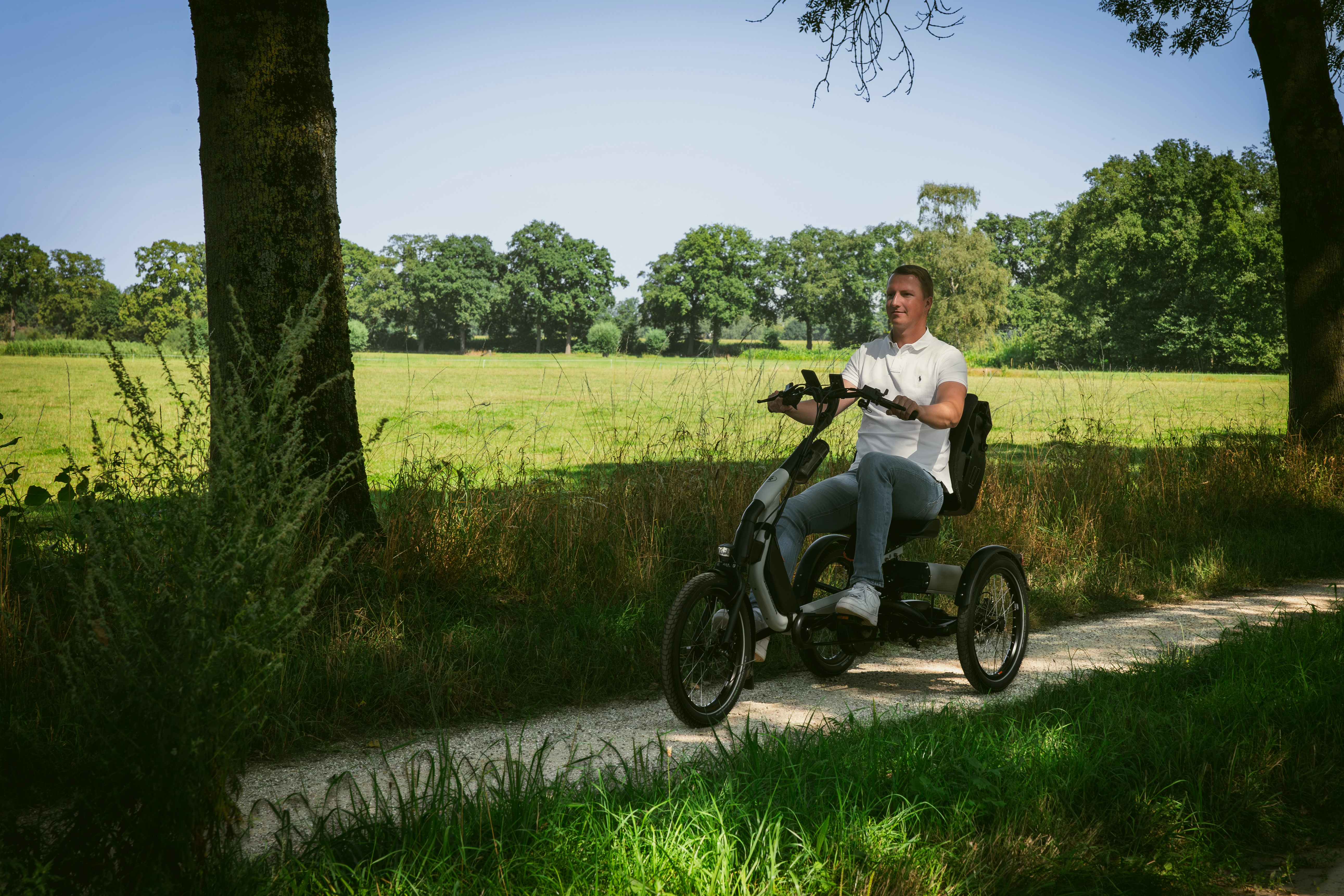 mann-fährt-easy-rider-explore-dreirad-in-grüner-landschaft
