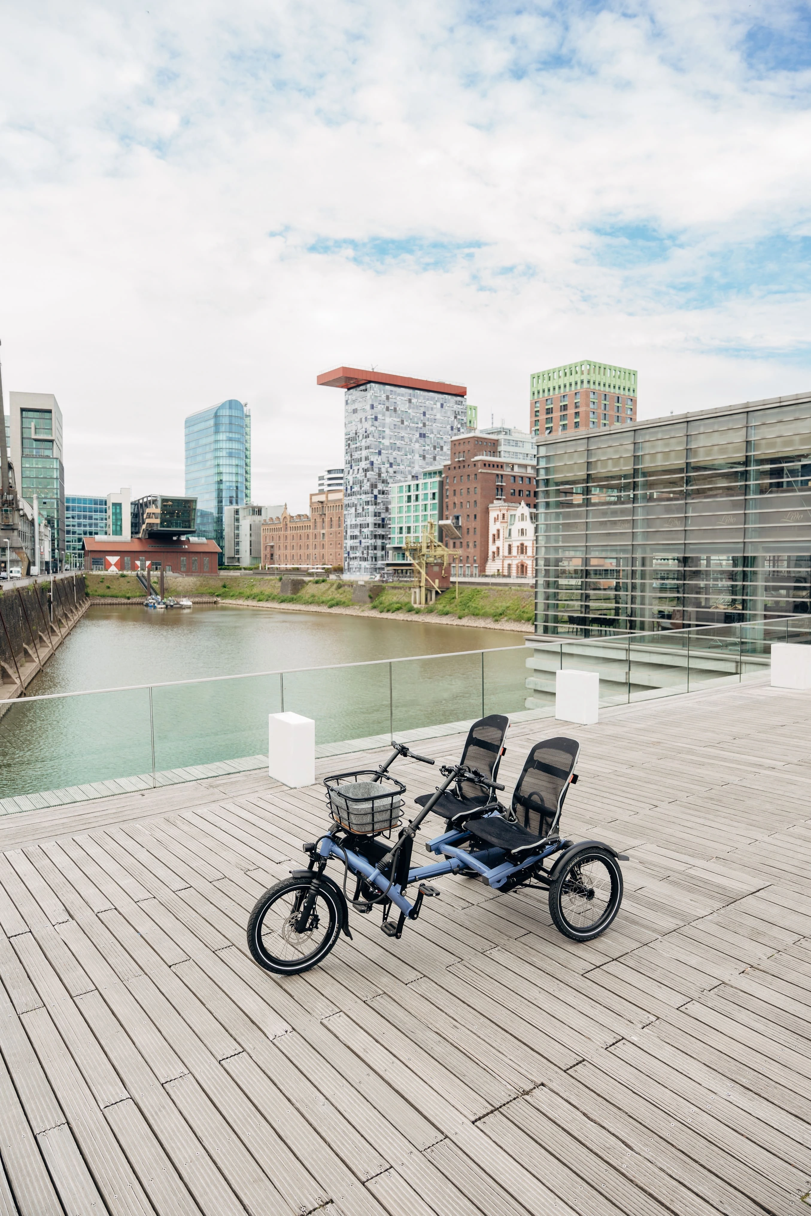 Kettwiesel TWO von Hase Bikes Paralleltandem steht auf einer Plattform vor enem Gewässer